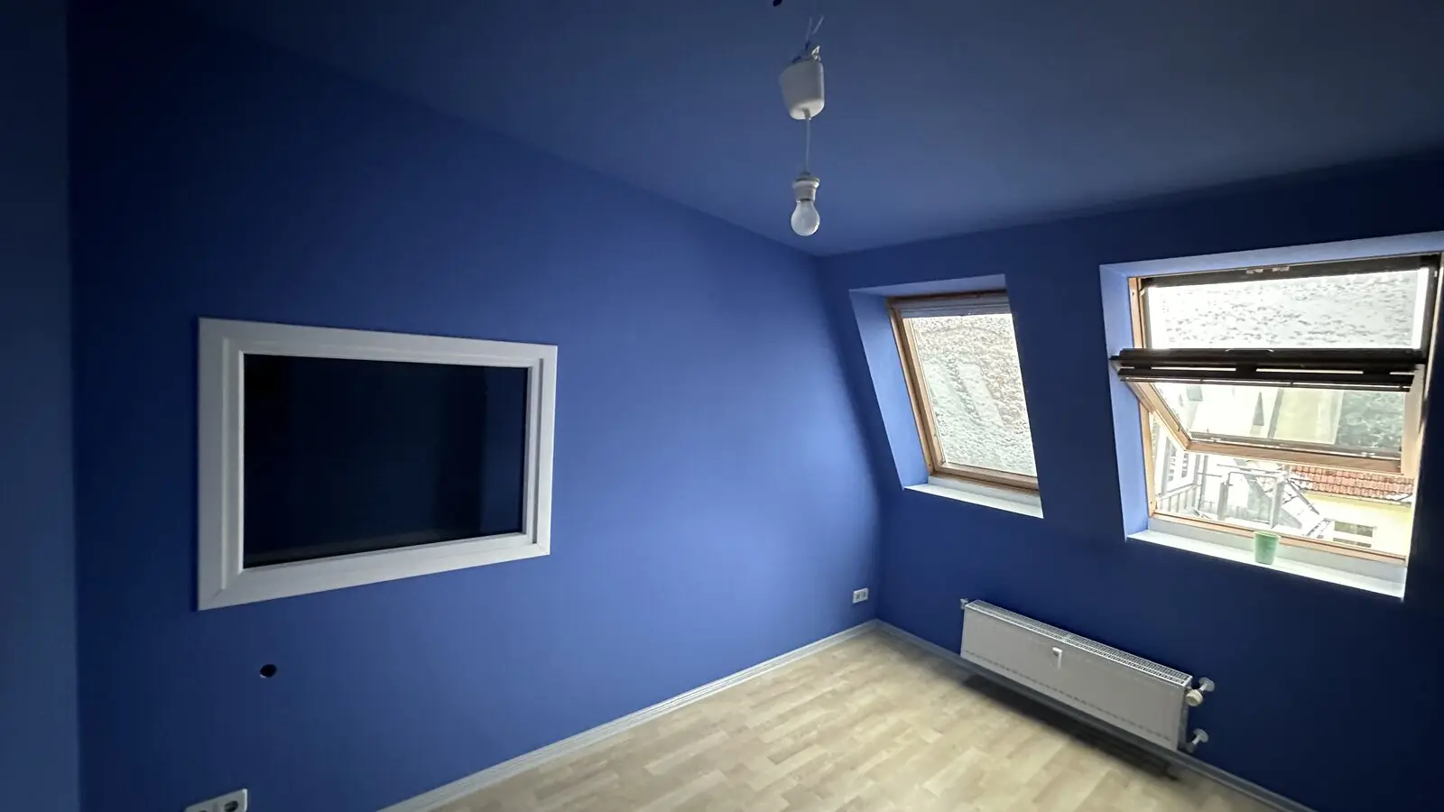 Blue room with laminate laid, wall opening and roof window