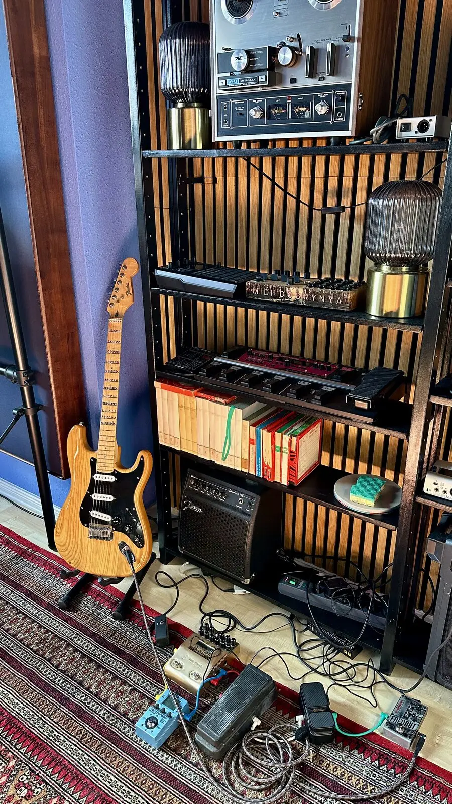 Slatted wall with a bass, a tape machine and books